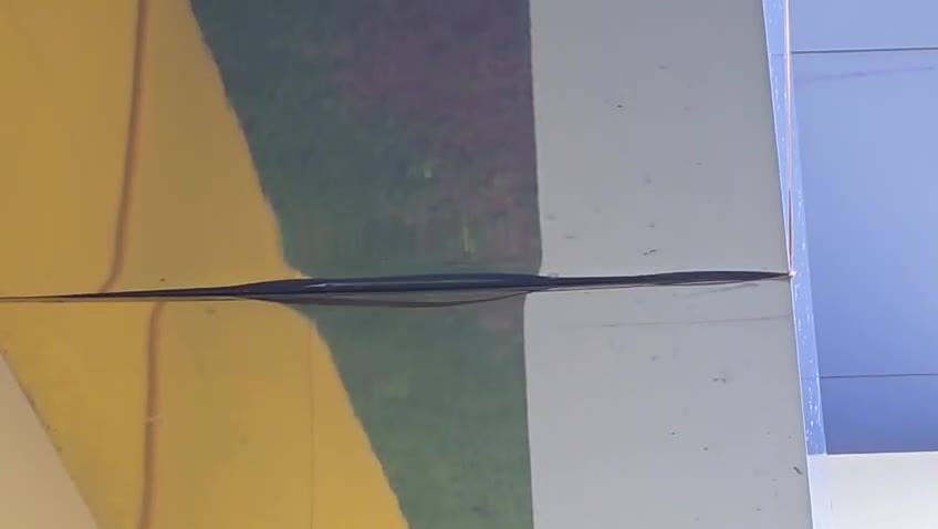 Fenda alongada aberta na superfície do painel (bordas afastadas no centro), entre áreas amarela e cinza (Colégio).